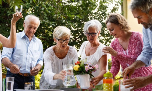 Residents standing outside at Arden at Indian Land Apartments in South Carolina featuring a flower vase and pitcher of water.