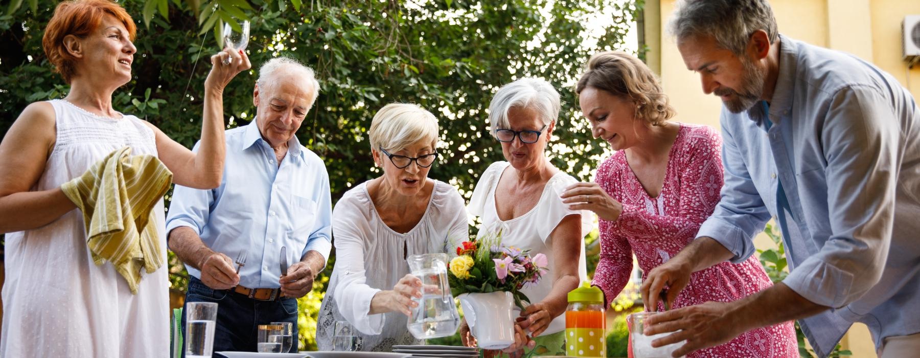 a group of people standing around a table with flowers