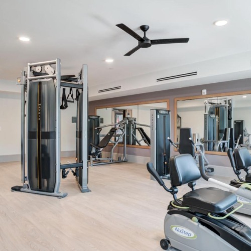 Cutting-edge amenities at your fingertips The fitness center at Arden at Indian Land Apartments in South Carolina, featuring wood grain flooring and exercise machines.